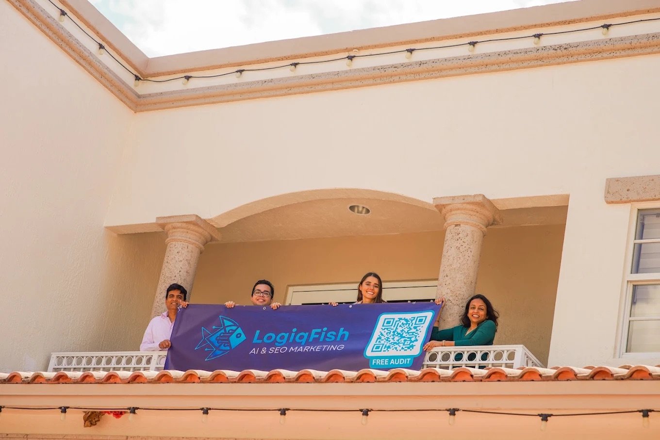 The LogiqFish team holding the LogiqFish AI & SEO Marketing banner on the balcony of their Weston, FL office